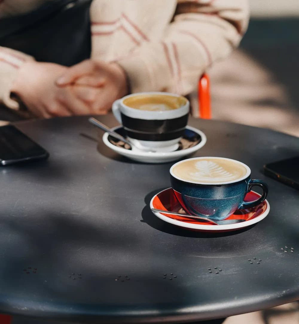 Twee koppen koffie op een zonnig terras, illustratieve stockfoto